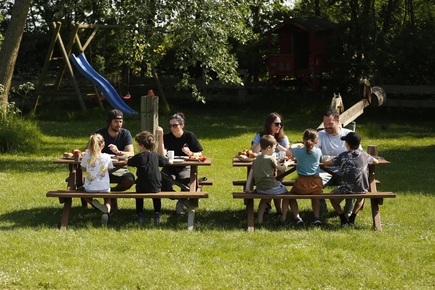 Gemeinsam draußen essen, mit dem Spielplatz im Hintergrund
